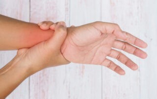 A person holding their wrist in pain signaling a hand injury