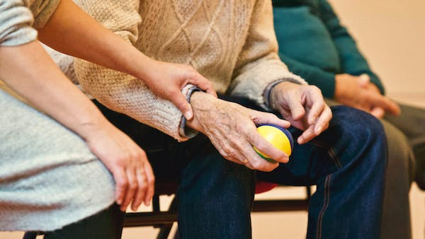 An elderly patient holding a ball