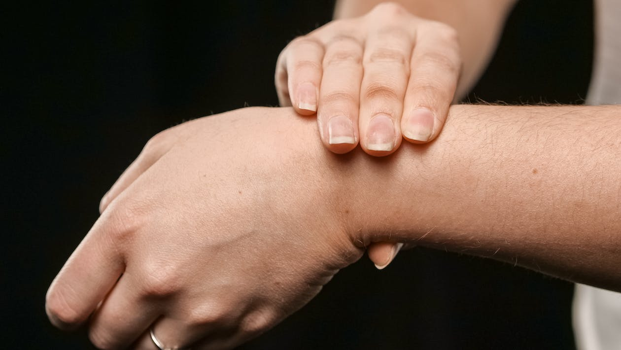 An image of a person pressing another’s wrist for recovery